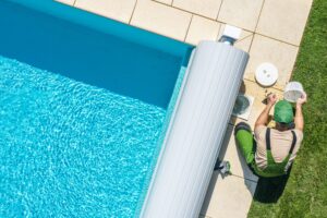 Caucasian Professional Garden SPA Technician Cleaning Skimmer Filter From Dirt. Outdoor Backyard Garden Swimming Pool Maintenance.