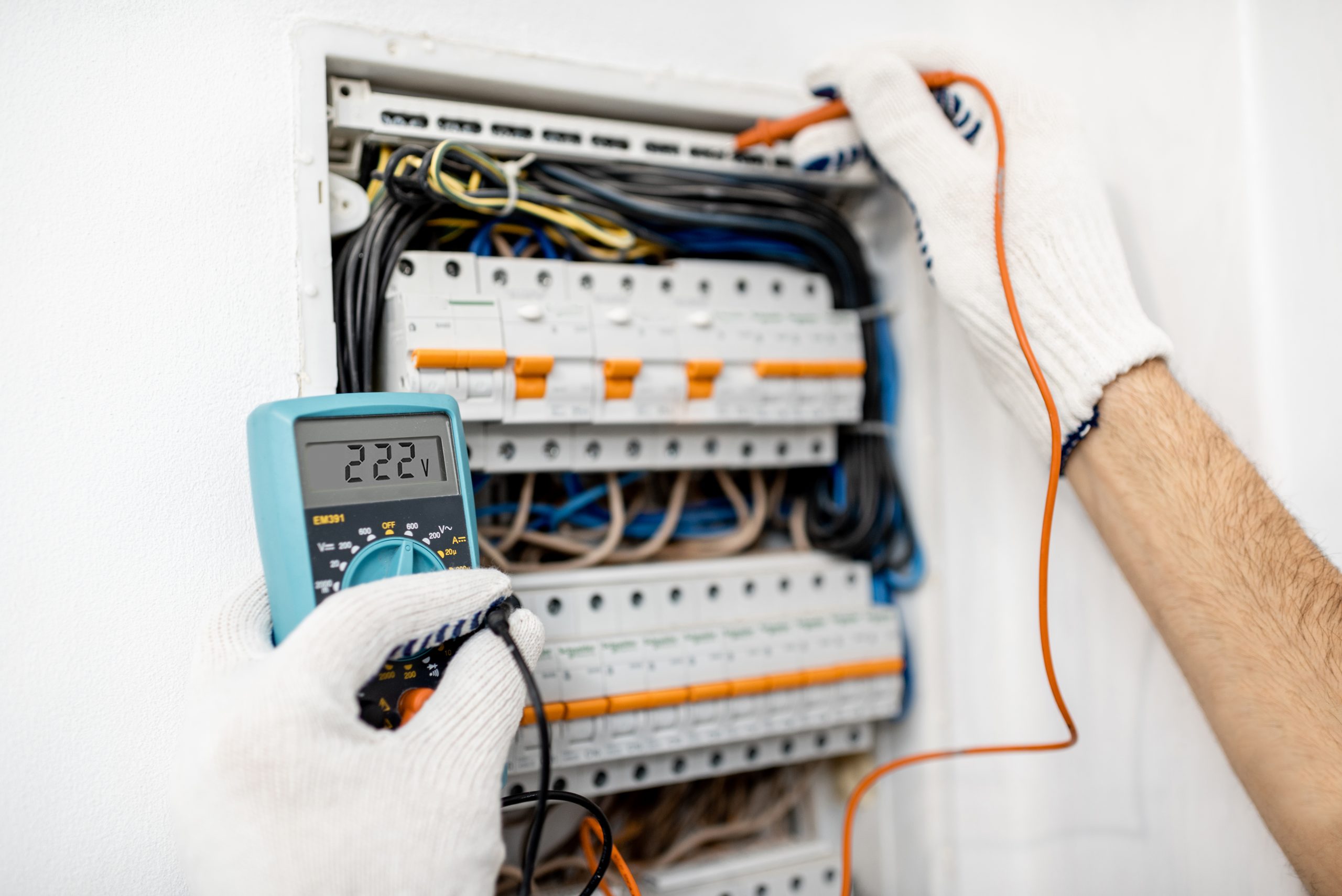Electrician installing or repairing apartment electrical panel, close-up view